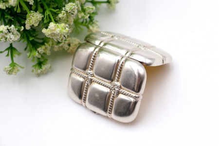 Caixa de comprimidos em prata com forma de mala de viagem com relevos e interior